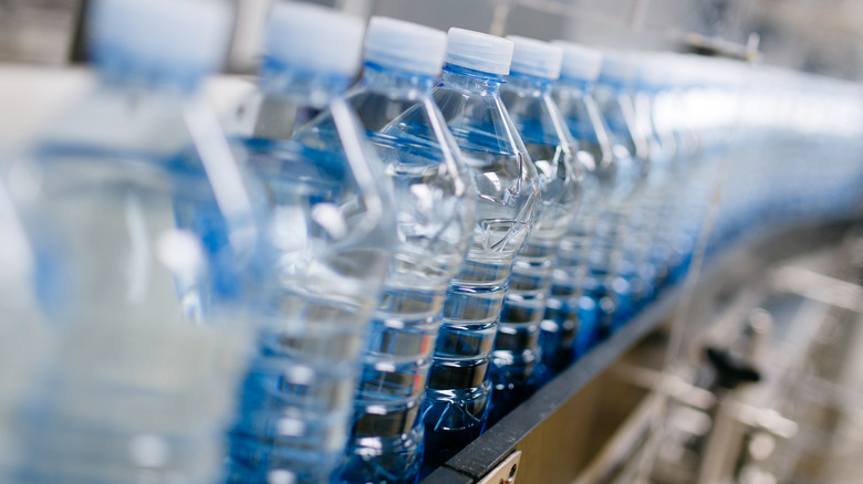 Individual plastic bottles of water on an assembly line.