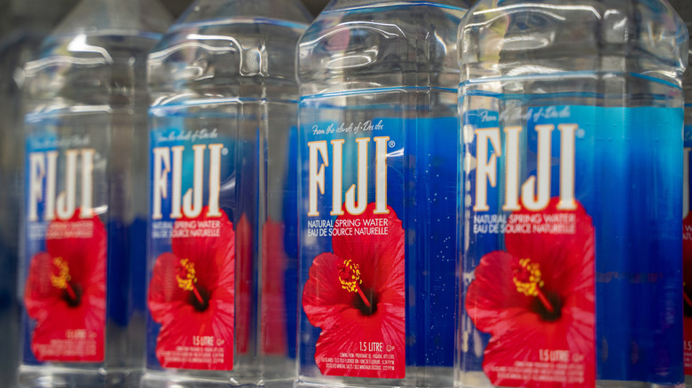 Four Fiji water bottles in a row.