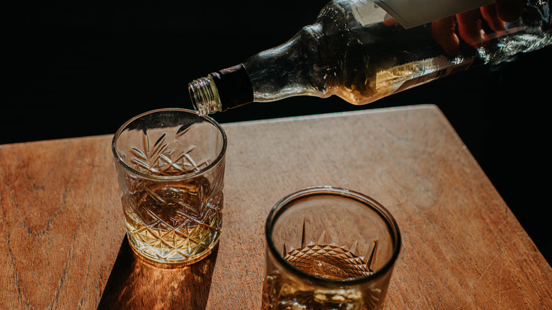 bourbon poured into glass from a bottle