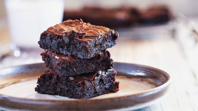 A stack of fudgy brownies on a plate.
