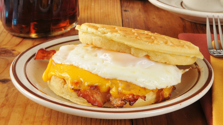 Bacon, egg, and cheese sandwich on a waffle on a plate