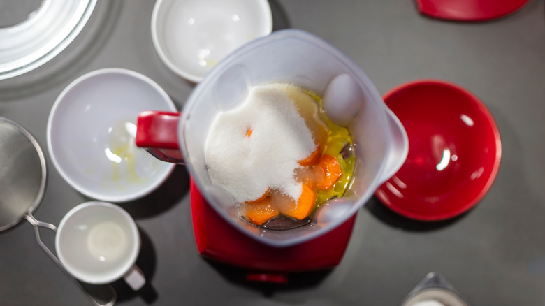 Overhead shot of a blender filled with carrot cake ingredients