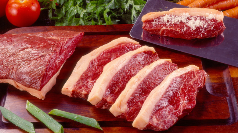 Picanha steaks are arranged on a cutting board.