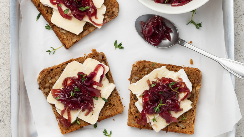 Toast with Brie and cranberry sauce on top near a spoon
