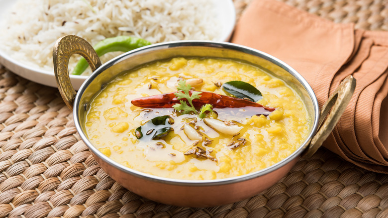 Yellow dal fry with curry leaves, dried chiles, and garlic next to rice