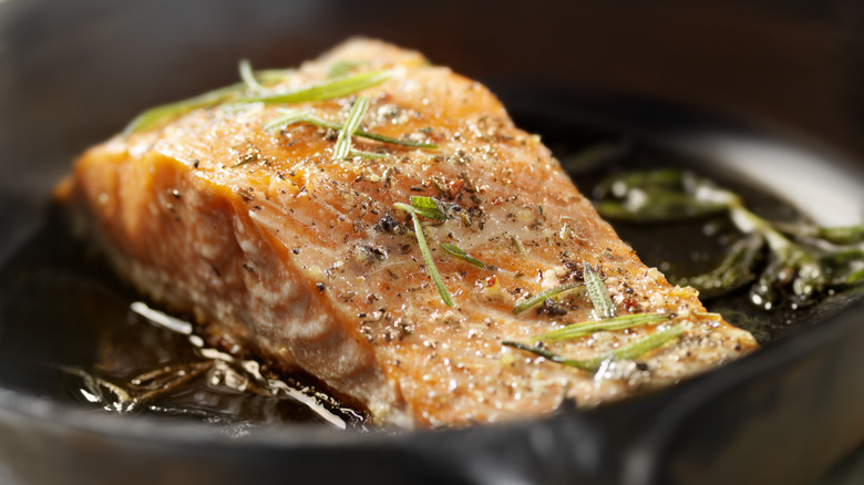 Salmon being seared in a frypan. 