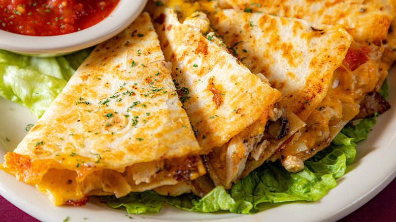 A quesadilla is plated with salsa.