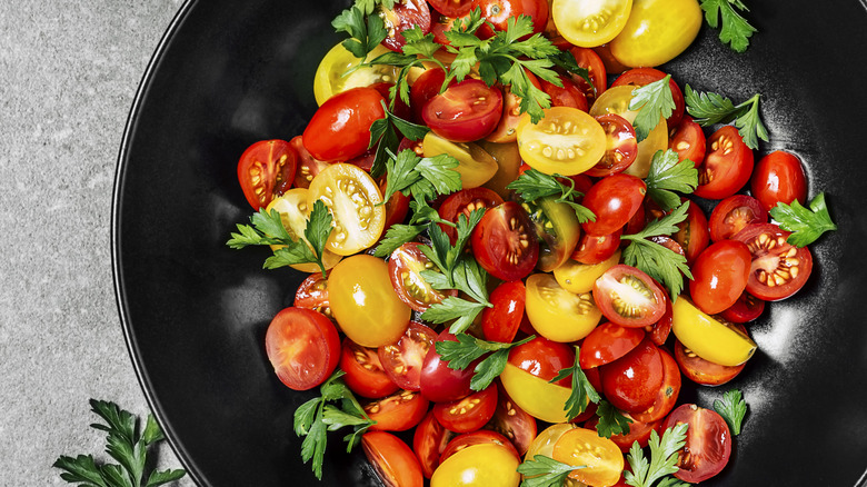 A bowl of tomato salad on gray background