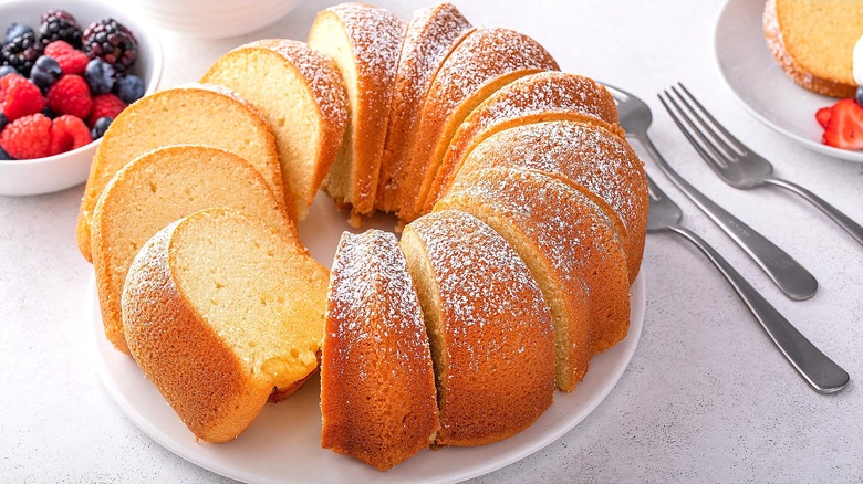 Sliced vanilla bundt cake with powdered sugar on a white plate