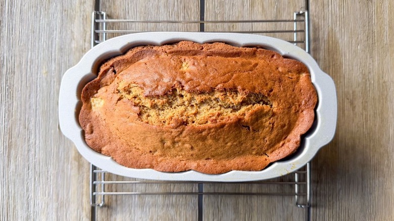 Brown butter bourbon loaf cake cooling in pan on rack
