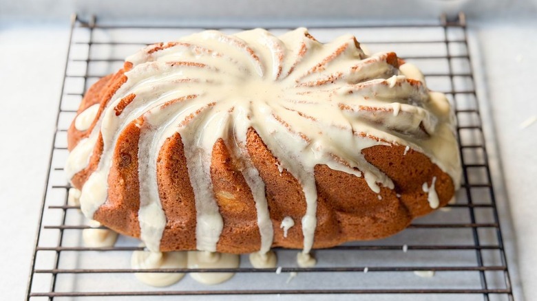 Glazed brown butter bourbon loaf cake on rack over parchment-lined baking sheet