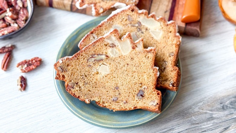 Slices of brown butter bourbon loaf cake on plate with pecans