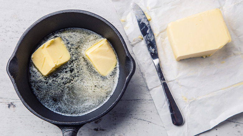 Two large pieces of butter melting in a pan.