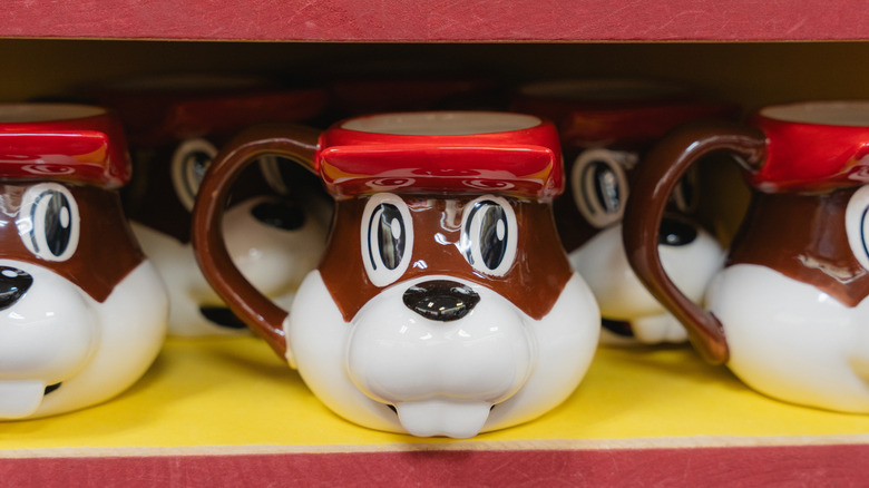 Shelf of Buc-ees mugs.