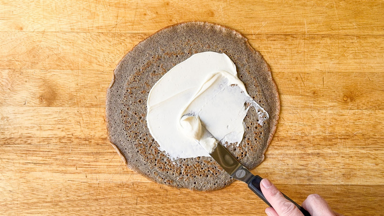 Spreading creme fraiche on a buckwheat crepe