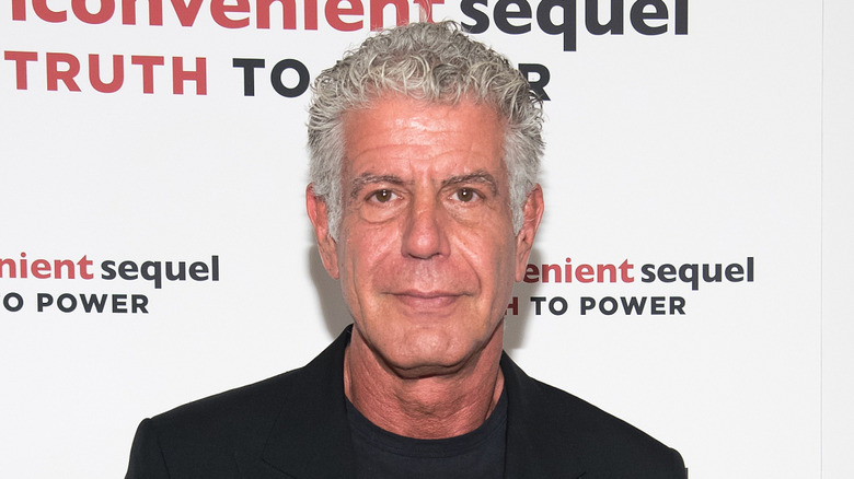 Anthony Bourdain in a black t-shirt and blazer at an event