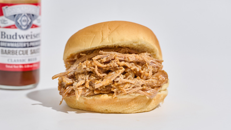 Classic beer barbecue sauce next to a pulled pork sandwich
