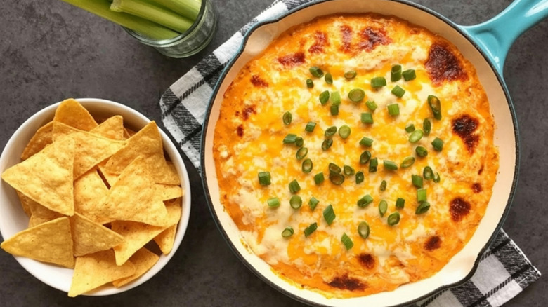 Top view of spicy buffalo chicken dip served with tortilla chips and celery sticks