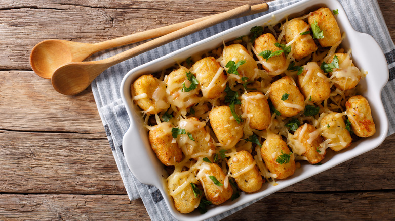 Small casserole dish topped with tater tots and shredded cheese