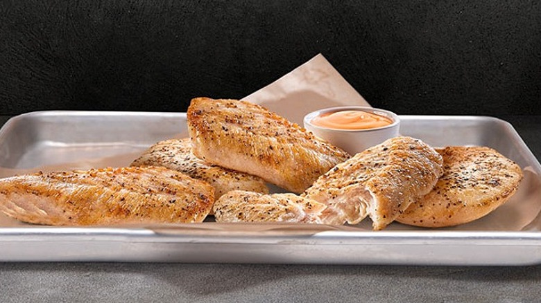 Tray of Buffalo Wild Wings Grilled Chicken with a container of sauce