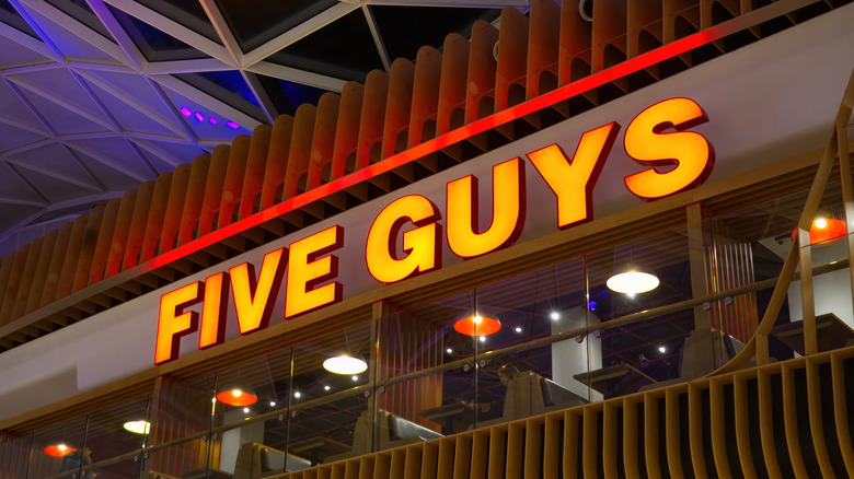 The exterior of a Five Guys restaurant at night