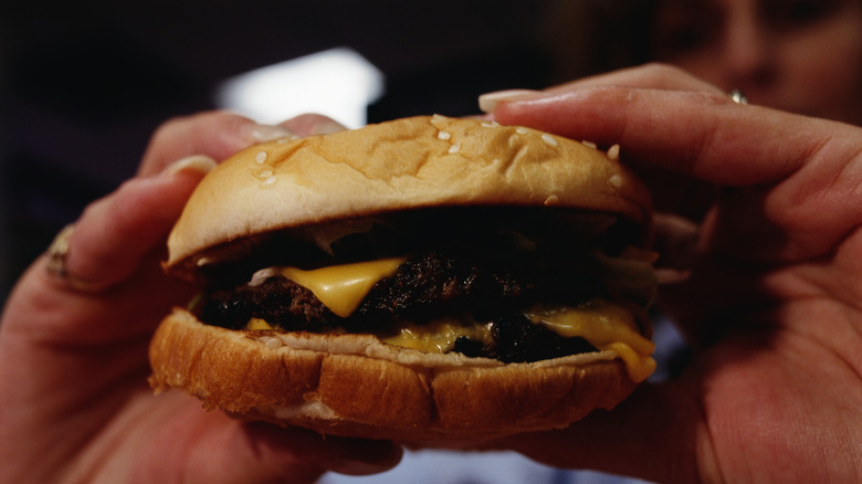 hands holding up a Burger King burger