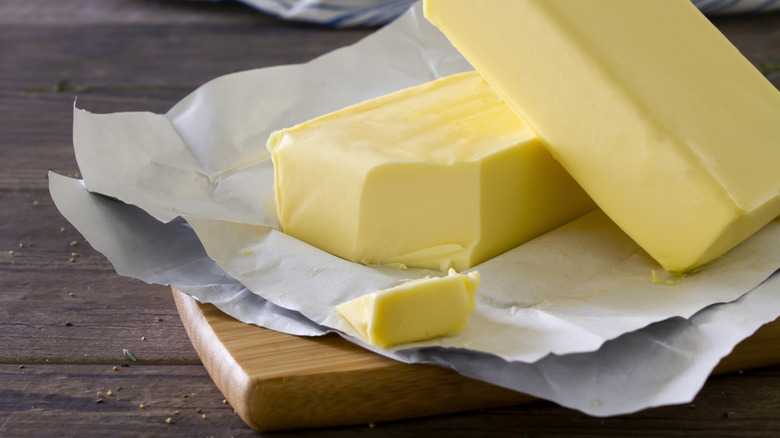 A block of butter sitting on top of paper packaging.