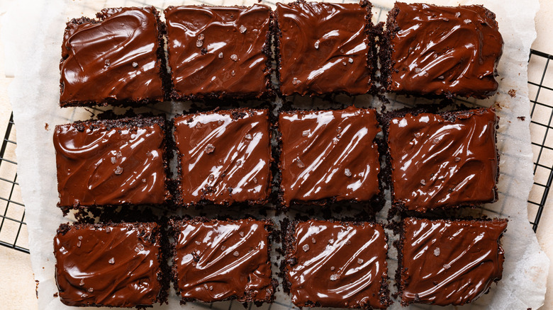 Chocolate-frosted brownie squares are photographed from overhead.