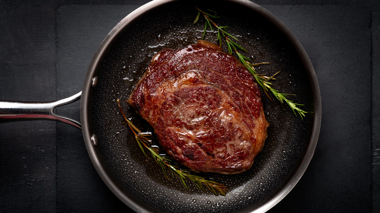 Steak in pan with herbs