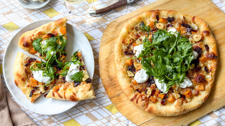 Butternut squash and maple bacon pizza on pizza peel and slices on plate