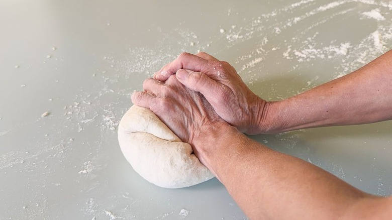 Kneading pizza dough on countertop