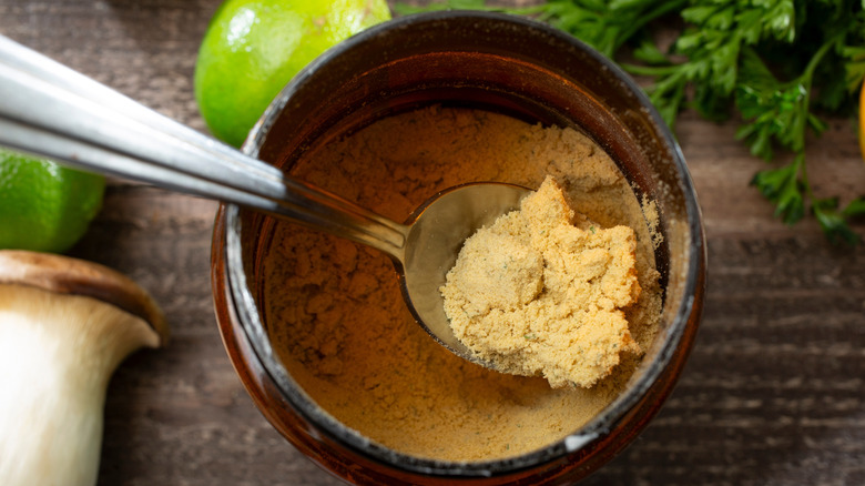 Spoon in an open jar of chicken bouillon powder.