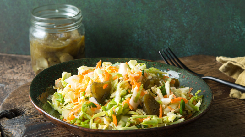 A bowl full of cabbage slaw with jalapeño peppers