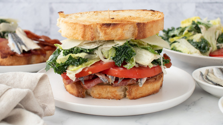 Side shot of a stacked BLT sandwich made with Caesar salad ingredients
