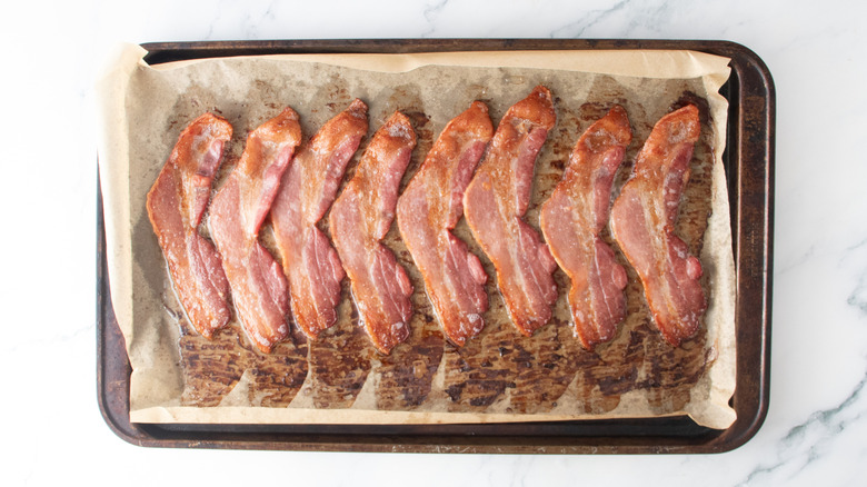 A large baking sheet topped with cooked bacon