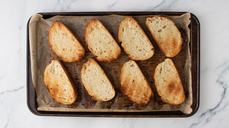 Toasted bread slices on a large baking sheet
