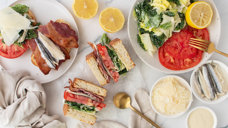 Overhead shot of caesar BLT sandwiches and toppings