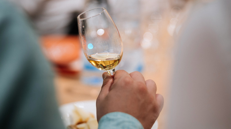 Person holding a tasting glass of whiskey