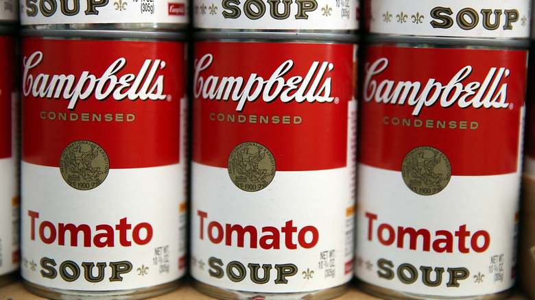 Cans of Campbell's Condensed Tomato Soup are lined on a store shelf