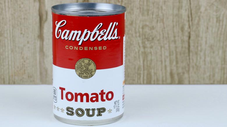 A can of Campbell's Condensed tomato soup against a wood grain background