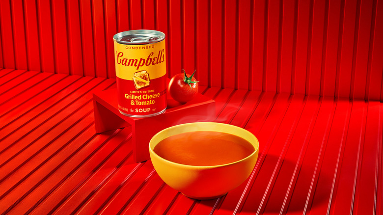 Campbell's Grilled Cheese & Tomato Soup canned and in a bowl on a red background.