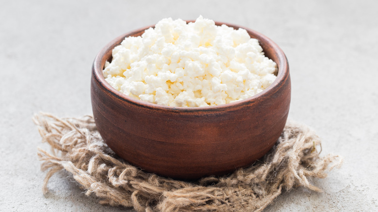 cottage cheese in a clay bowl on a towel