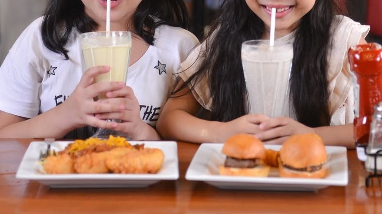 Two children eating kids meals and drinking milkshakes at Chili's