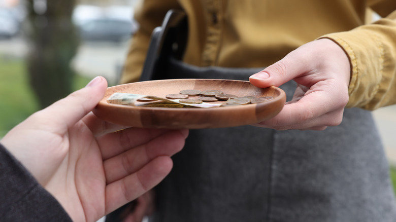 A customer handing a tip to a restaurant server.