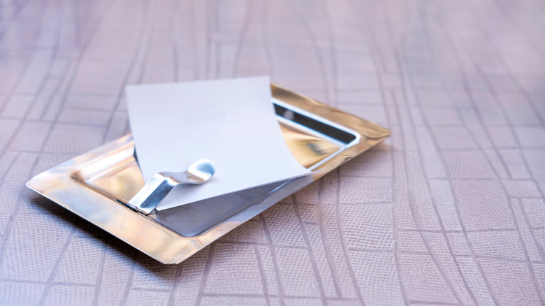 A restaurant check on a small tray.