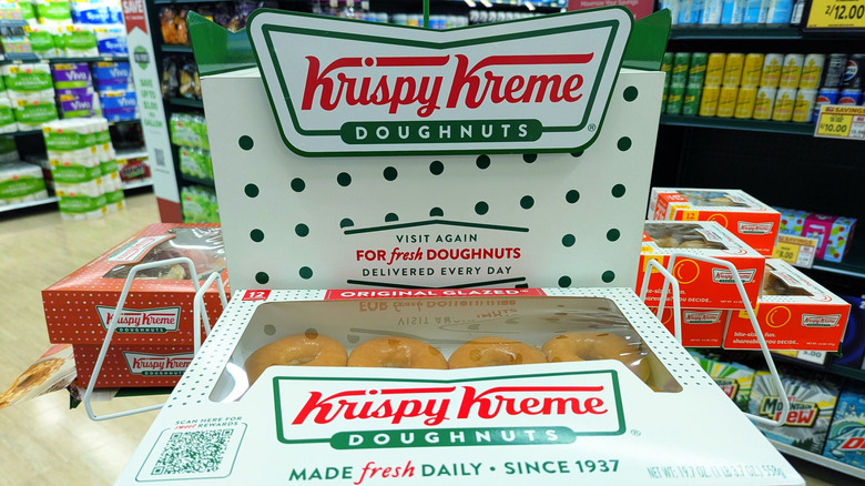 Krispy Kreme display stand with box of glazed donuts