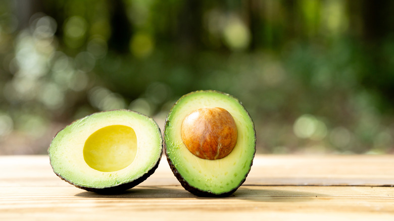 Avocado cut in half on a wooden table