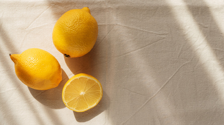 Lemons are positioned on a light fabric.