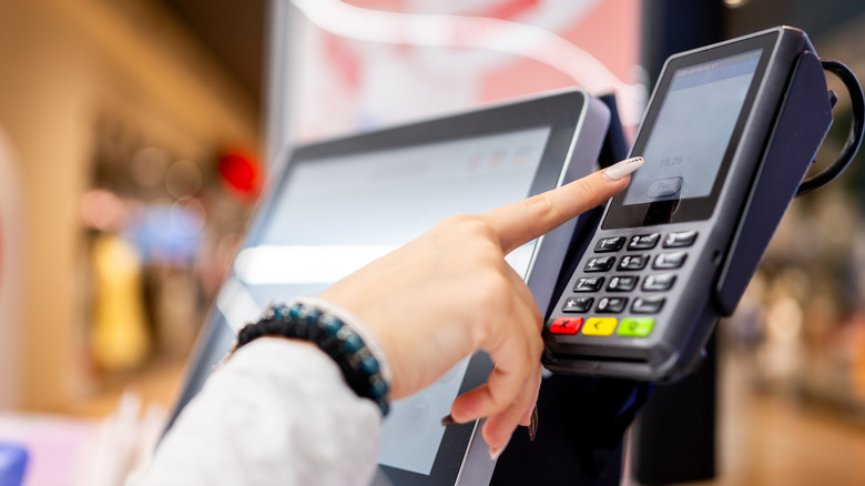 Close-Up Of A Girl Paying For Groceries At Self-Checkout