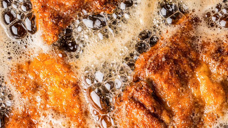 Chicken frying in bubbling fat